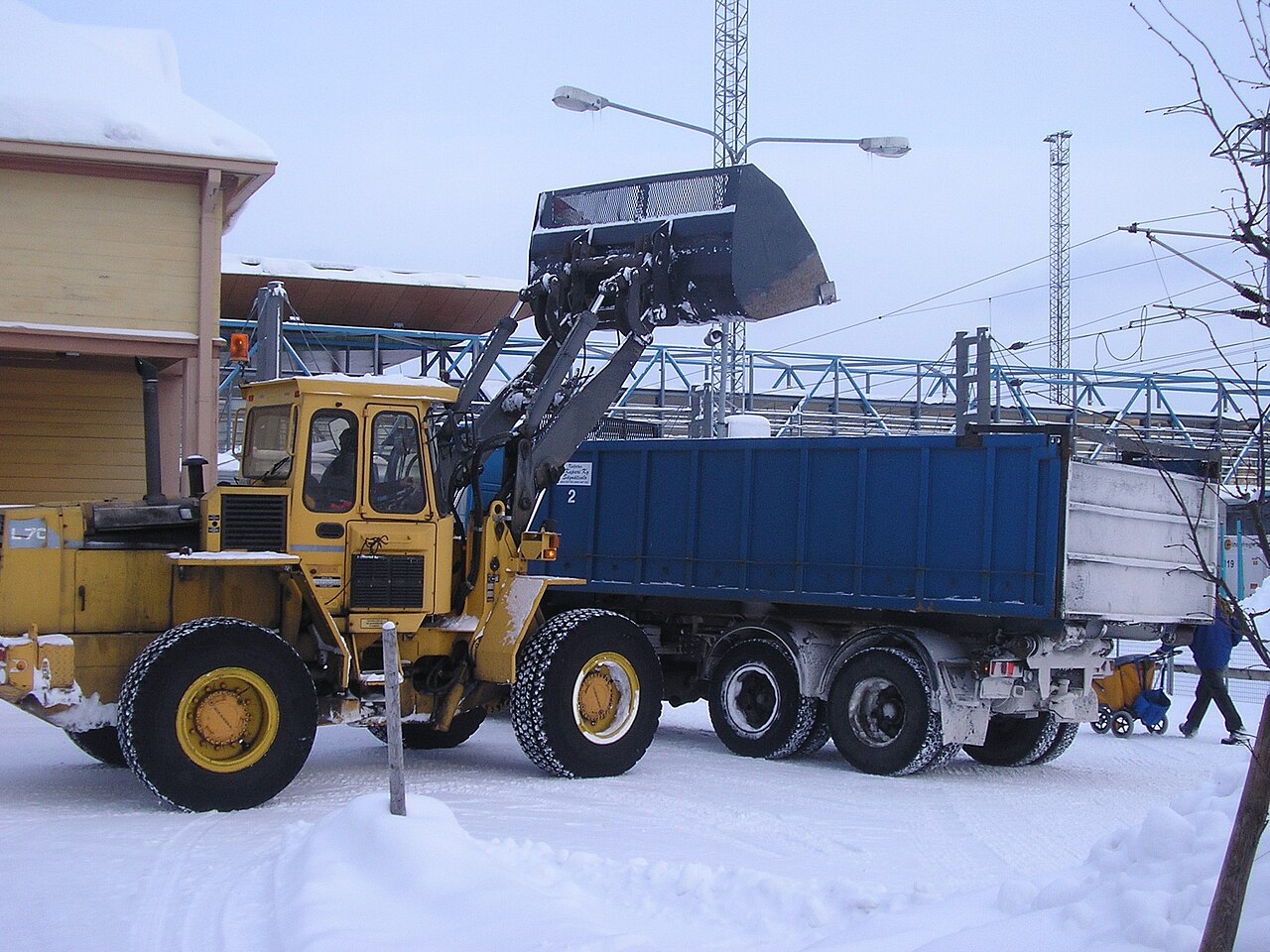 Lader lädt Schnee auf einen Lkw zum Abtransport