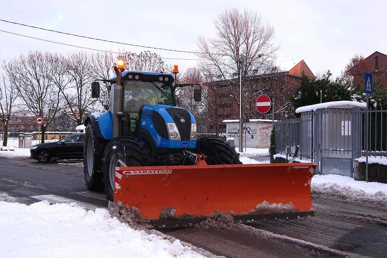Räumfahrzeug räumt einen verschneiten Parkplatz